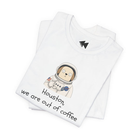 A folded white t-shirt with a cartoon astronaut graphic and the text 'Houston, we are out of coffee' printed on the front, displayed on a clean white background.