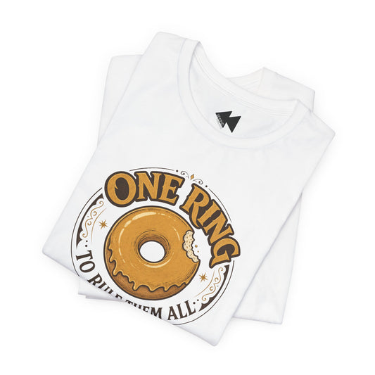 A folded white t-shirt with a graphic print of a glazed donut inside a circular emblem with the text 'ONE RING TO RULE THEM ALL'.