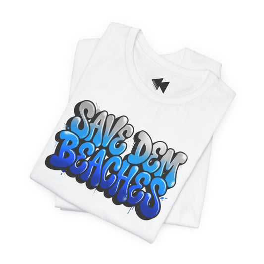 A folded white t-shirt featuring a colorful graffiti-style graphic that reads 'SAVE DEM BEACHES' in blue, gray, and black, set against a plain white background.