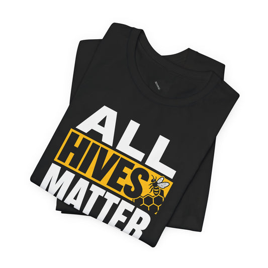 A folded black t-shirt with a bold graphic reading 'ALL HIVES MATTER' in white and yellow, featuring a bee and honeycomb design, on a plain white background.