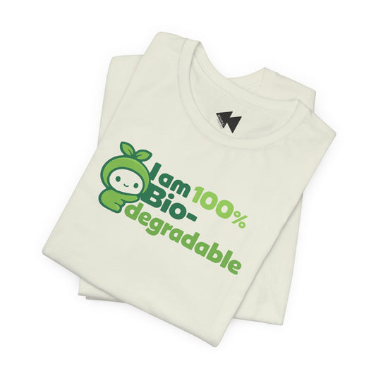 A folded off-white t-shirt with a green graphic that reads 'I am 100% Bio-degradable' next to a cartoon character wearing a leafy green hood. The shirt is displayed on a clean white background.