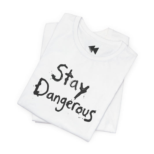 A folded white t-shirt with the words 'Stay Dangerous' printed in a black distressed brush font on the front, displayed on a clean white background.