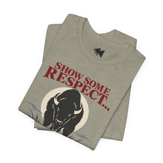 A folded heather gray t-shirt featuring a black bison illustration and the text 'SHOW SOME RESPECT I'M LAKOTA