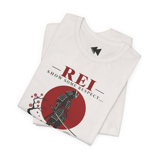 A folded white t-shirt with a graphic print featuring a samurai warrior, a red sun, cherry blossoms, and the text 'REI SHOW SOME RESPECT.