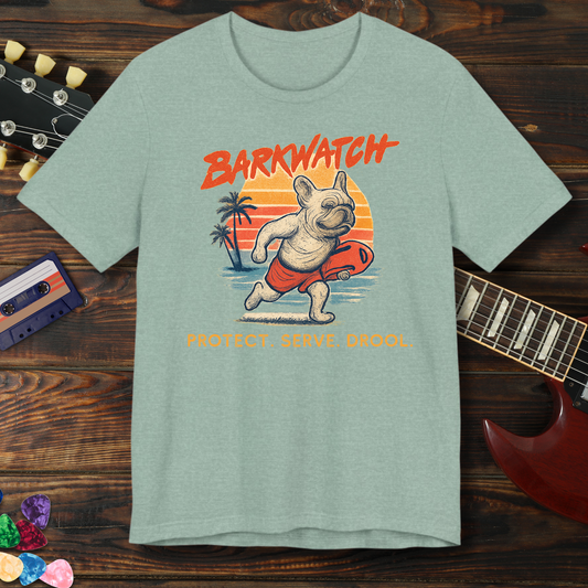 Green t-shirt with a dog graphic and 'Barkwatch' text on a wooden surface with a guitar and cassette tape.