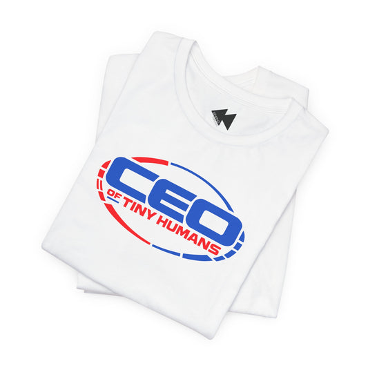 A folded white short-sleeve t-shirt with a graphic print on the front reading 'CEO OF TINY HUMANS' in blue and red, with a small black logo inside the collar.
