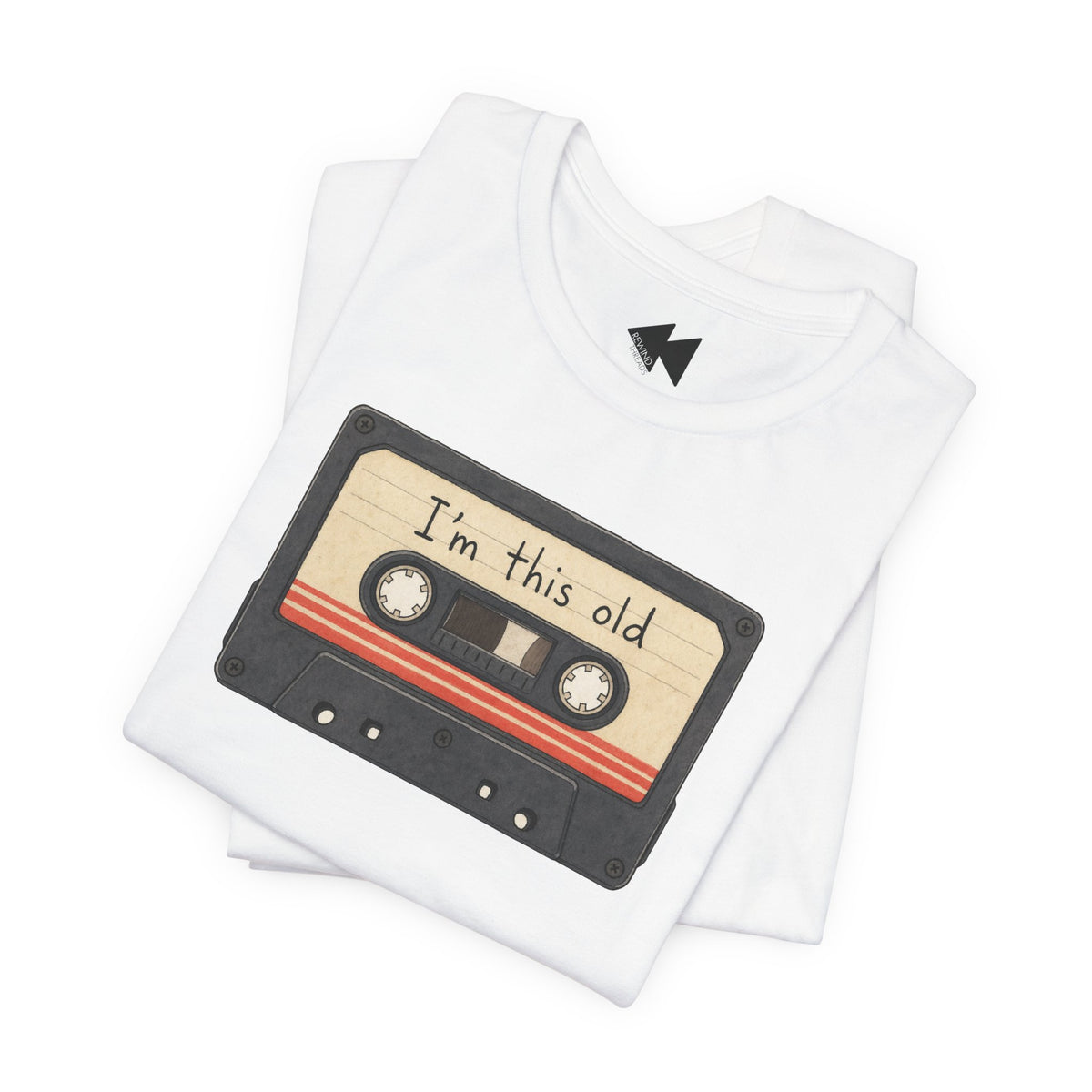 A folded white t-shirt featuring a graphic of a retro cassette tape with the text 'I'm this old' written on it, set against a plain white background.