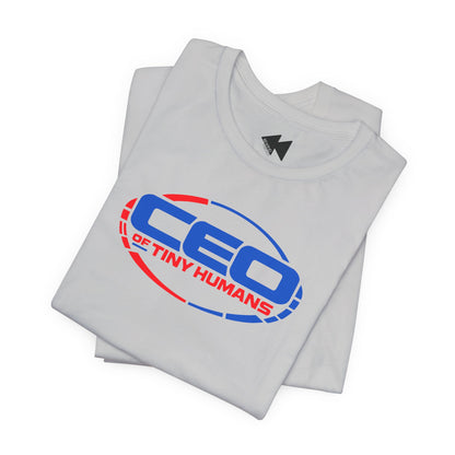 A folded white t-shirt with a graphic print on the front reading 'CEO OF TINY HUMANS' in blue and red, with a small black logo inside the collar.