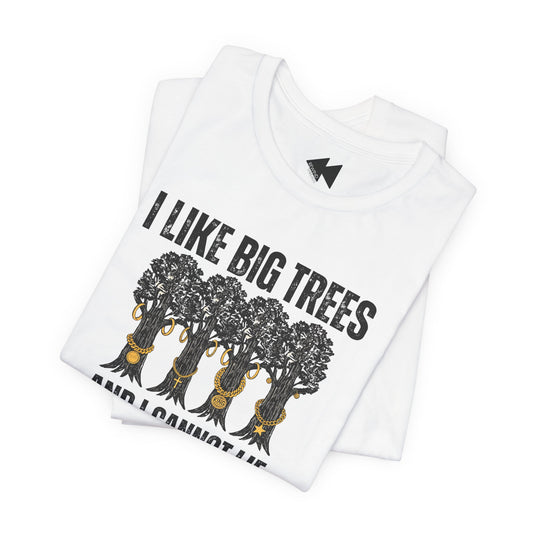 A folded white short-sleeve T-shirt with a black graphic print of five trees wearing gold necklaces beneath the text 'I LIKE BIG TREES' and 'AND I CANNOT LIE' in black, shown on a plain white background.