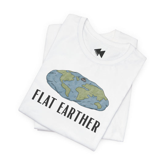 A folded white t-shirt with a graphic of a flat earth map in blue and green, with the text 'FLAT EARTHER' printed below in black. A small black lightning bolt logo is visible inside the collar.