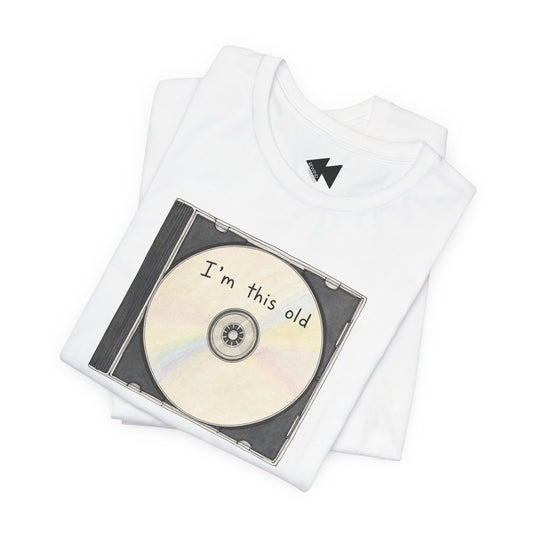 A folded white t-shirt featuring a graphic print of a CD with the text 'I'm this old' on a plain white background.