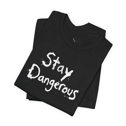 A folded black t-shirt with the words 'Stay Dangerous' printed in a black distressed brush font on the front, displayed on a clean white background.