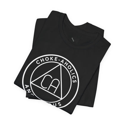 A folded black t-shirt with a black circular graphic on the front reading 'CHOKE-AHOLICS' around a triangle with 'CA' inside, shown on a plain white background.