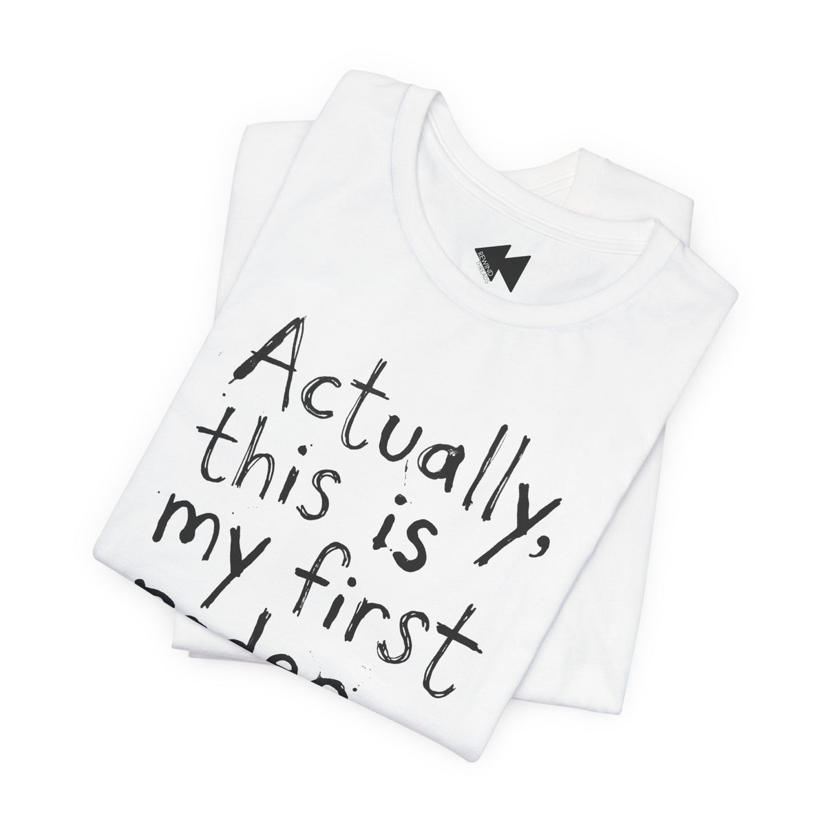 A folded white t-shirt with black handwritten-style text reading 'Actually, this is my first...' on a plain white background.
