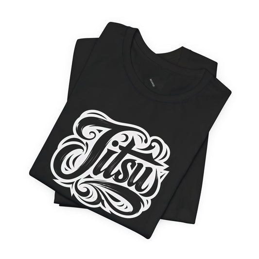 A folded black t-shirt with a large white stylized graphic reading 'Jitsu' on the front, displayed on a clean white background.