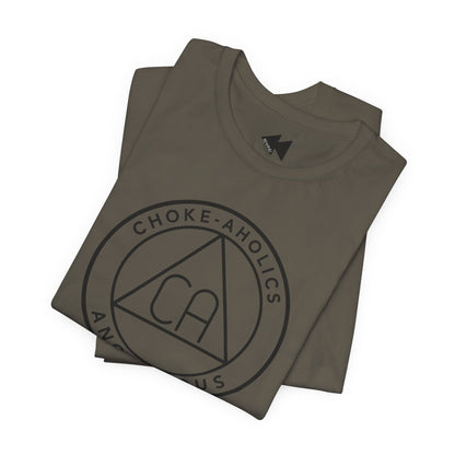 A folded army t-shirt with a black circular graphic on the front reading 'CHOKE-AHOLICS' around a triangle with 'CA' inside, shown on a plain white background.