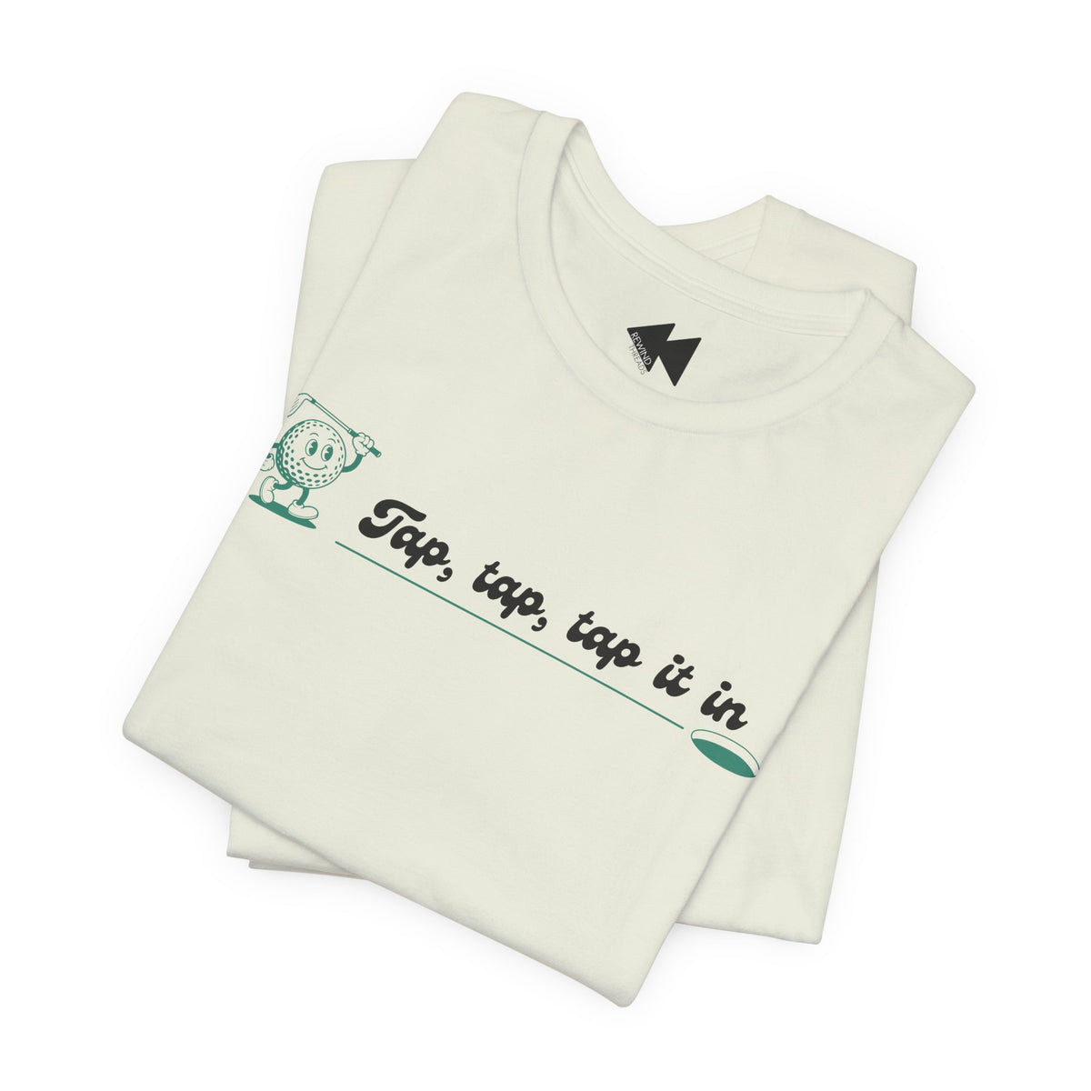A folded off-white t-shirt with a green cartoon character and the text 'Tap, tap, tap it in' printed on the front, displayed on a clean white background.