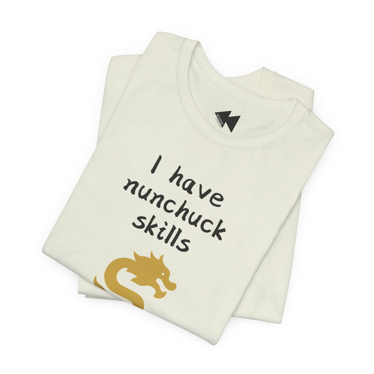 A folded off-white t-shirt with the text 'I have nunchuck skills' in black handwritten-style font and a gold dragon graphic, shown on a plain white background.