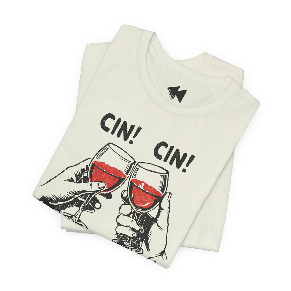 A folded off-white t-shirt featuring a graphic of two hands clinking wine glasses filled with red wine, with the text 'CIN! CIN!' printed above. A small black geometric logo is visible inside the collar.