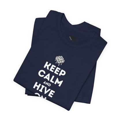 A folded navy blue t-shirt with a white graphic print that reads 'KEEP CALM AND HIVE ON' beneath a dripping bee illustration, displayed on a clean white background.