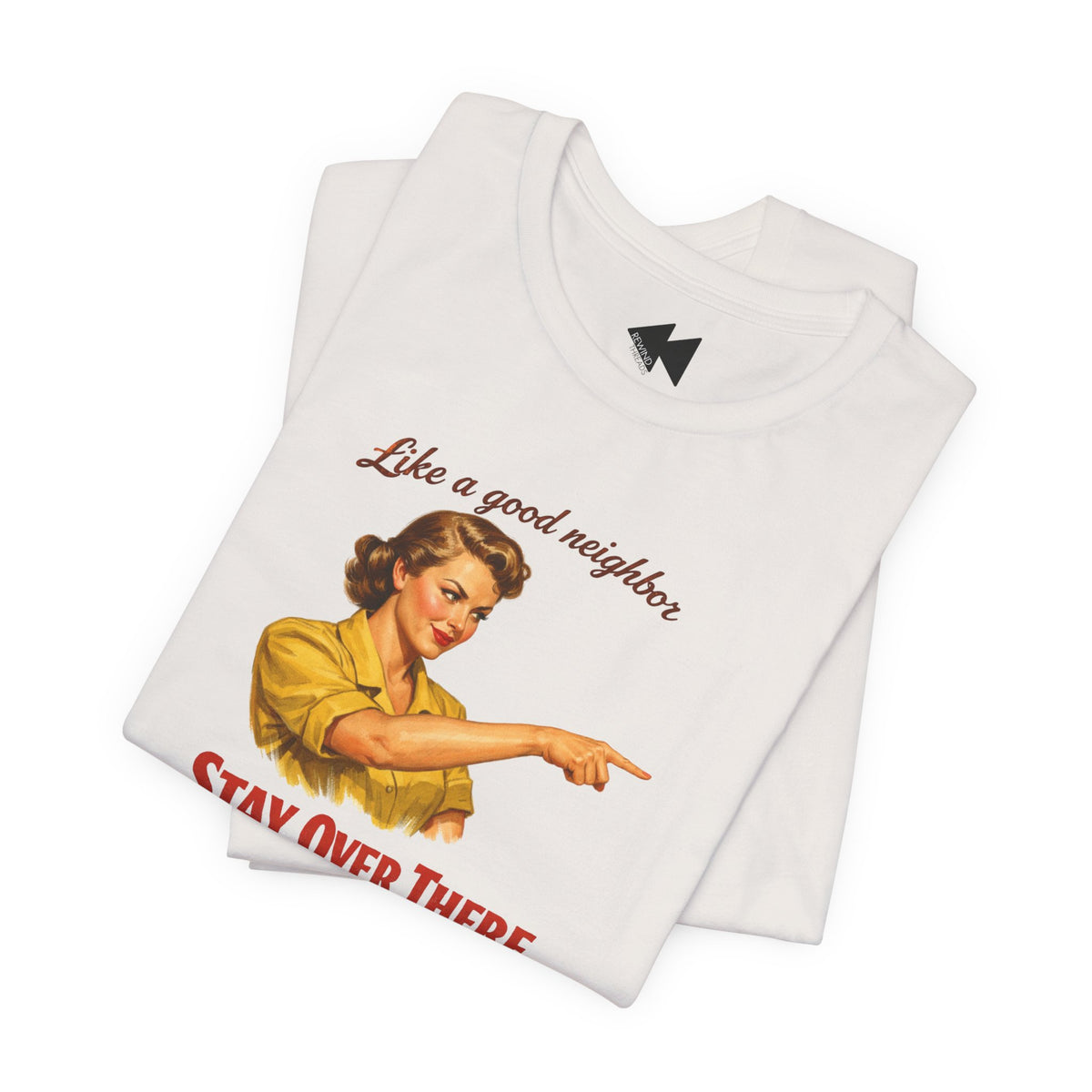 A folded white t-shirt featuring a vintage-style graphic of a woman in a yellow shirt pointing, with the text 'Like a good neighbor' in brown script and 'STAY OVER THERE' in red at the bottom.