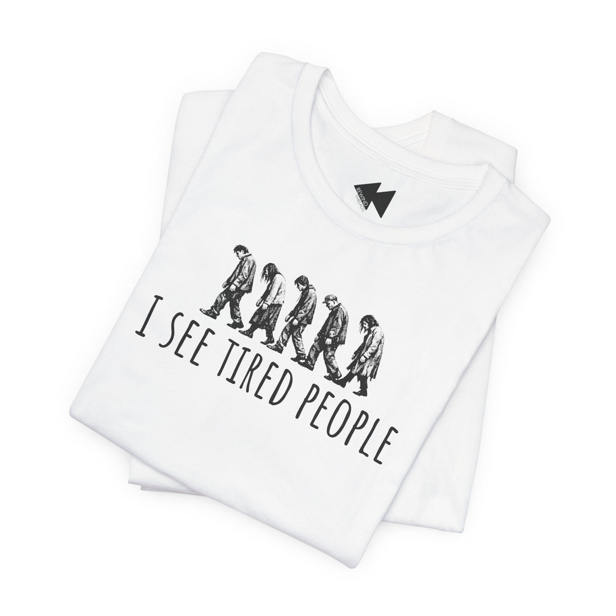 A folded white t-shirt with a black graphic print showing a line of walking figures and the text 'I SEE TIRED PEOPLE'. A small black lightning bolt logo is printed inside the collar.