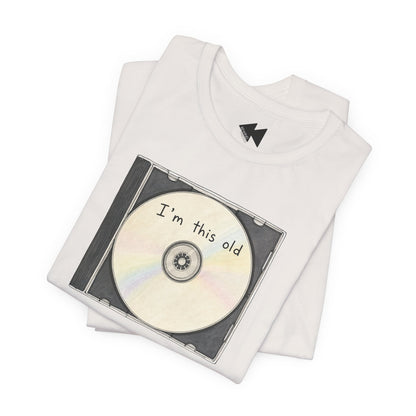A folded white t-shirt featuring a graphic print of a CD with the text 'I'm this old' on a plain white background.
