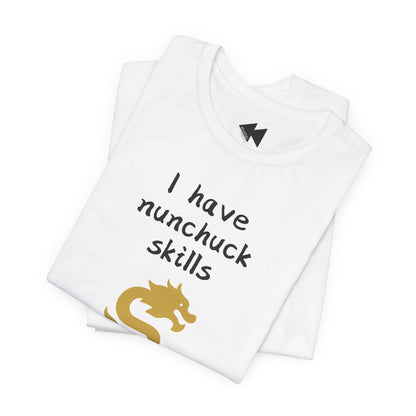 A folded white t-shirt with the text 'I have nunchuck skills' printed in black, accompanied by a gold dragon graphic near the bottom, displayed on a clean white background.