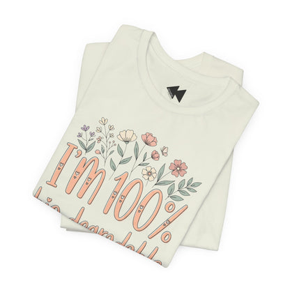 A folded citron green t-shirt that reads 'I'm 100% bio-degradable' in peach-colored lettering, decorated with small pastel flowers above the text.