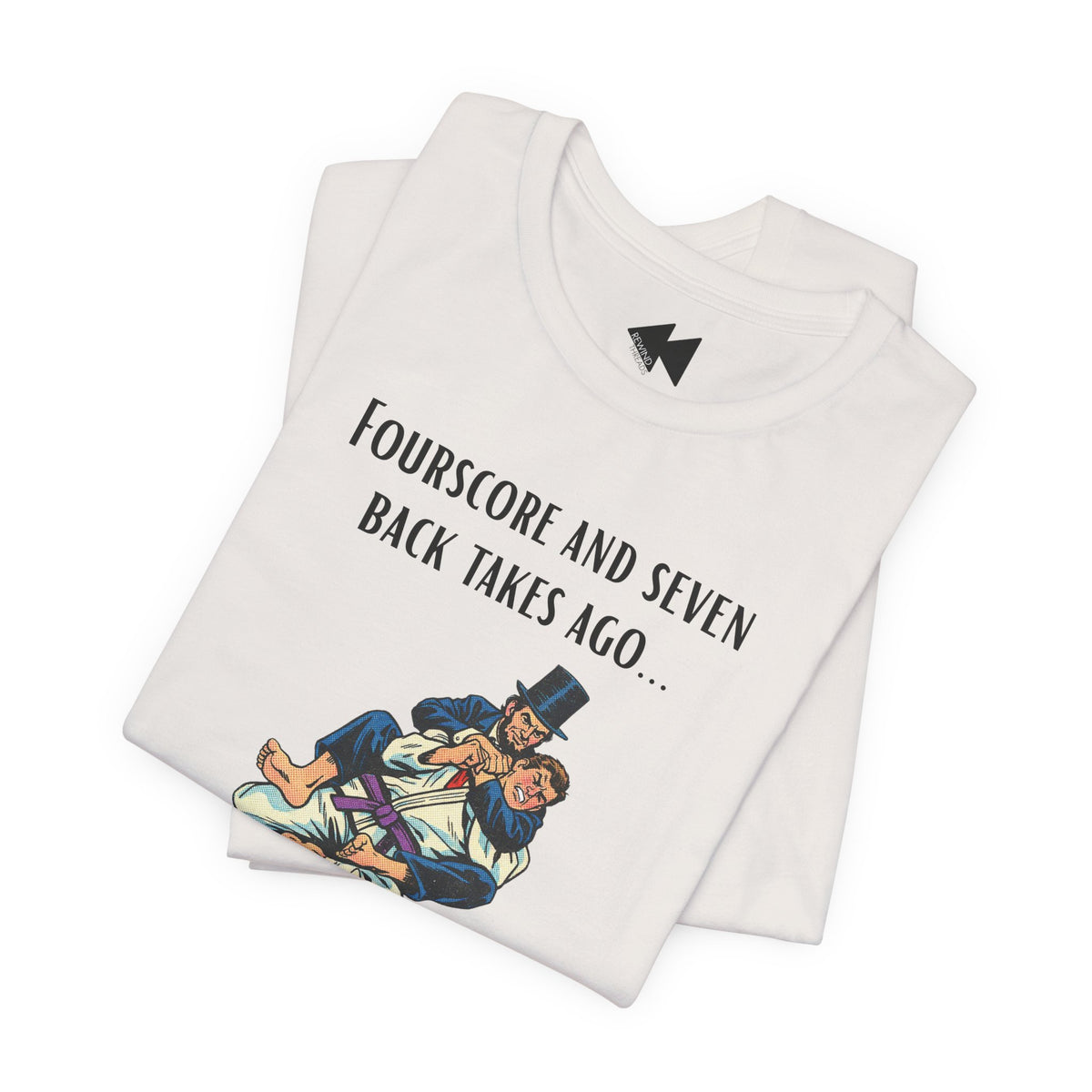 A folded light beige t-shirt with a black graphic print that reads 'Fourscore and Seven Back Takes Ago.
