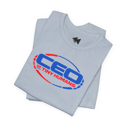 A light blue folded t-shirt with a graphic print reading 'CEO OF TINY HUMANS' in blue and red inside an oval outline, shown on a plain white background.