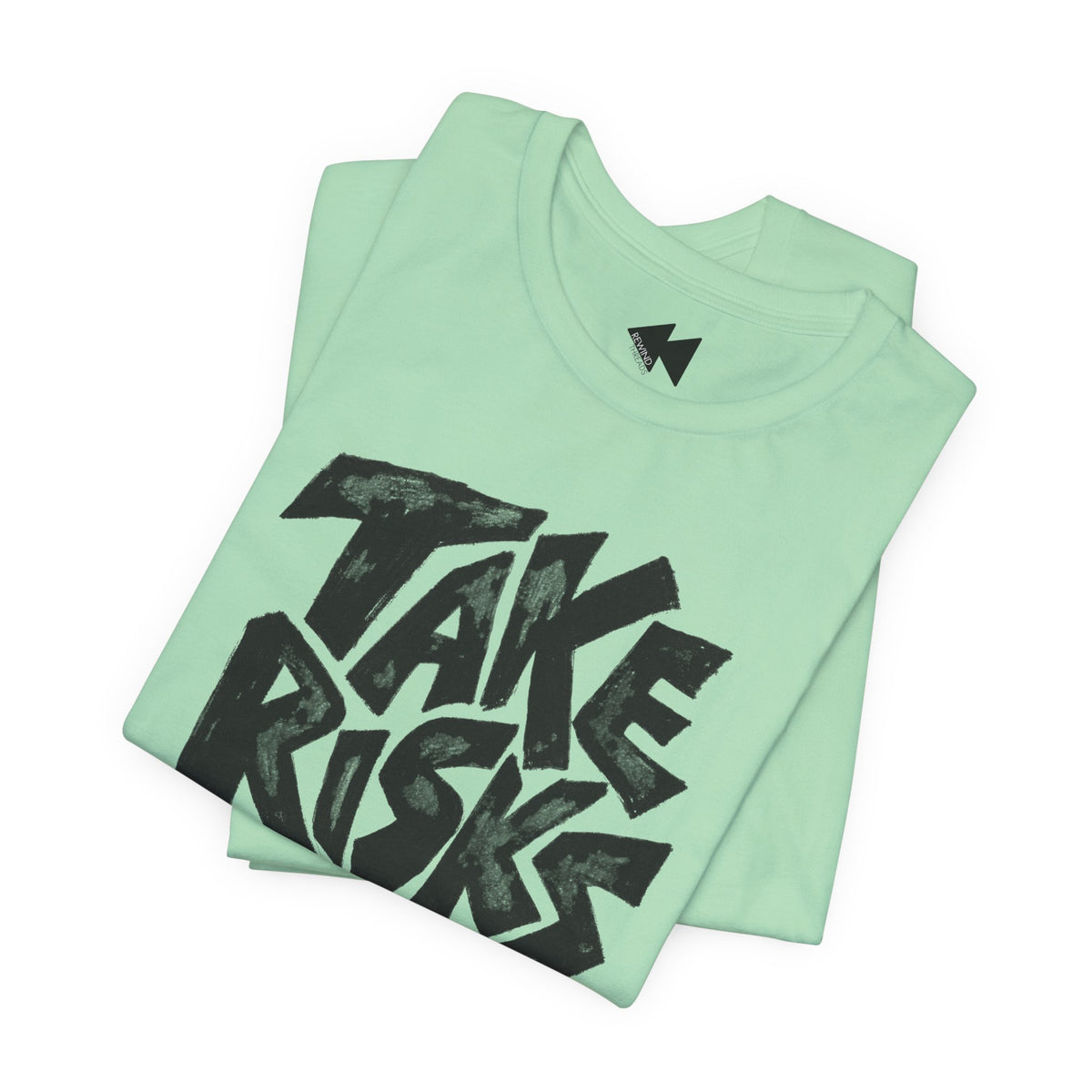 A folded mint green t-shirt with a bold black graphic reading 'TAKE RISKS' across the front, displayed on a clean white background.