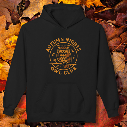 Black hoodie with 'Autumn Nights Owl Club' design on a background of autumn leaves.