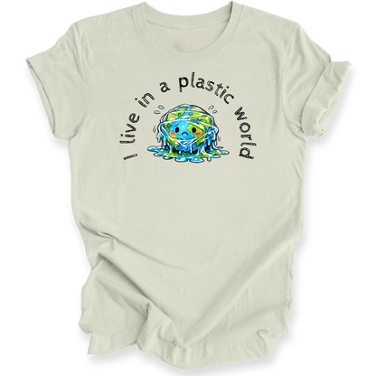A light beige short-sleeve t-shirt with a graphic on the front showing a melting blue and green Earth with the text 'I live in a plastic world' arched above and below it, displayed on a clean white background.