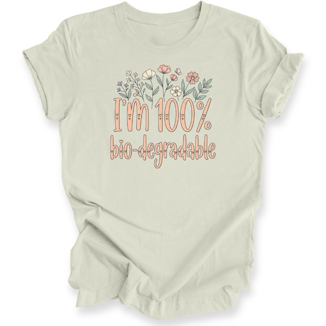 A light citron green t-shirt with a graphic print that reads 'I'm 100% bio-degradable' in peach-colored lettering, decorated with a small floral illustration above the text.