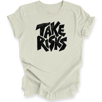 A light beige crewneck t-shirt with a bold black graphic text reading 'TAKE RISKS' in a stylized, slightly distressed font, displayed on a clean white background.