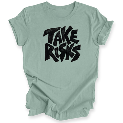 A sage green short-sleeve t-shirt with a black graphic text print reading 'TAKE RISKS' in a stylized, bold font, displayed on a clean white background.
