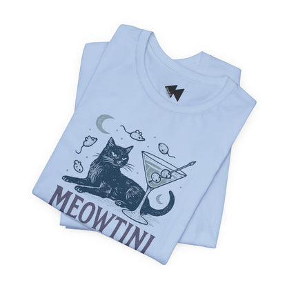 A folded light blue t-shirt with a graphic print of a black cat sitting next to a martini glass, with the word 'MEOWTINI' printed below in dark gray. The shirt is displayed on a clean white background.