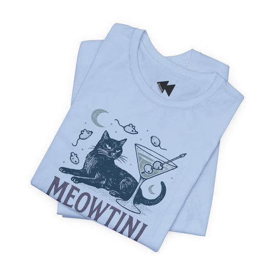 A folded light blue t-shirt with a graphic print of a black cat sitting next to a martini glass, with the word 'MEOWTINI' printed below in dark gray. The shirt is displayed on a clean white background.