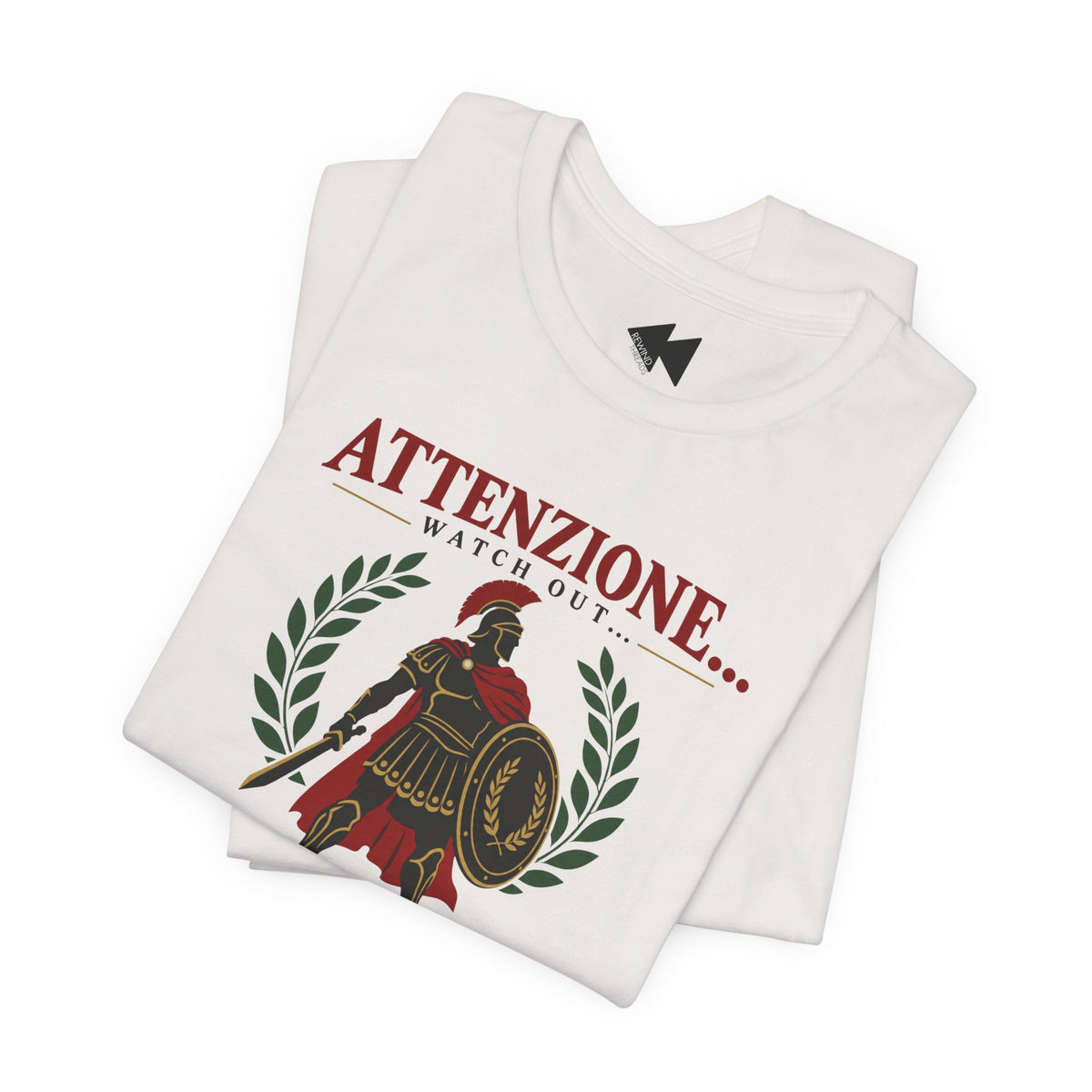A folded white t-shirt with a graphic print featuring a Roman soldier, laurel wreath, and the text 'ATTENZIONE.