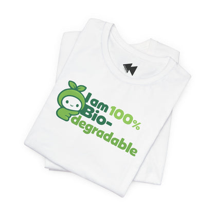 A folded white t-shirt with a green graphic that reads 'I am 100% Bio-degradable' next to a cartoon apple character, shown on a plain white background.