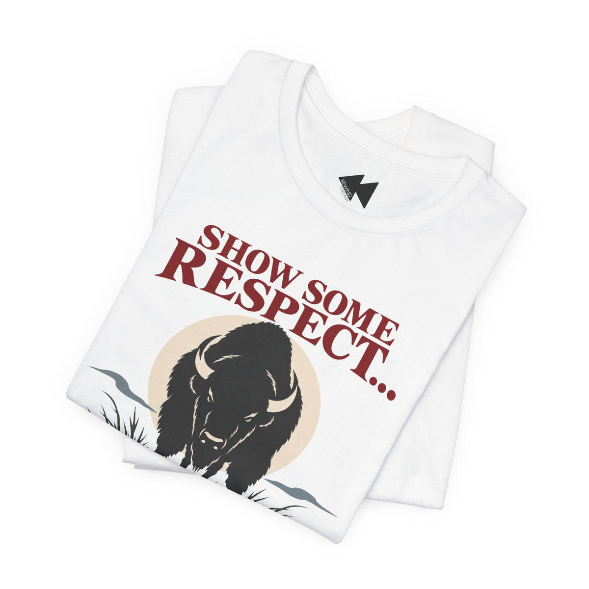 A folded white t-shirt  featuring a black bison illustration and the text 'SHOW SOME RESPECT I'M LAKOTA