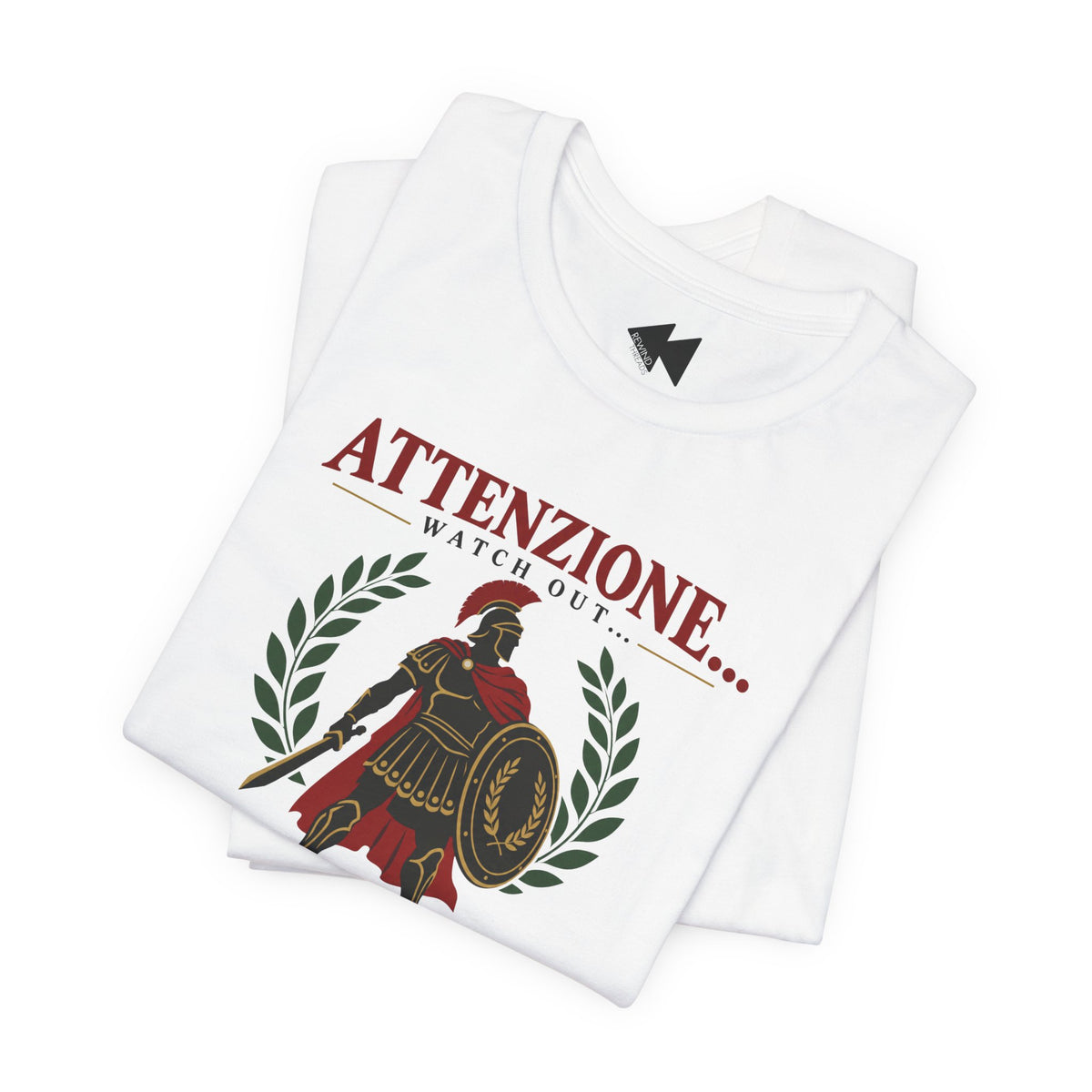 A folded white t-shirt with a graphic print featuring a Roman soldier, laurel wreath, and the text 'ATTENZIONE.