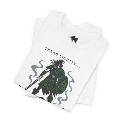 A folded white crewneck t-shirt with a graphic print of a Irish tartan warrior holding a shield and sword, accompanied by the text 'Tread lightly I'm Irish".