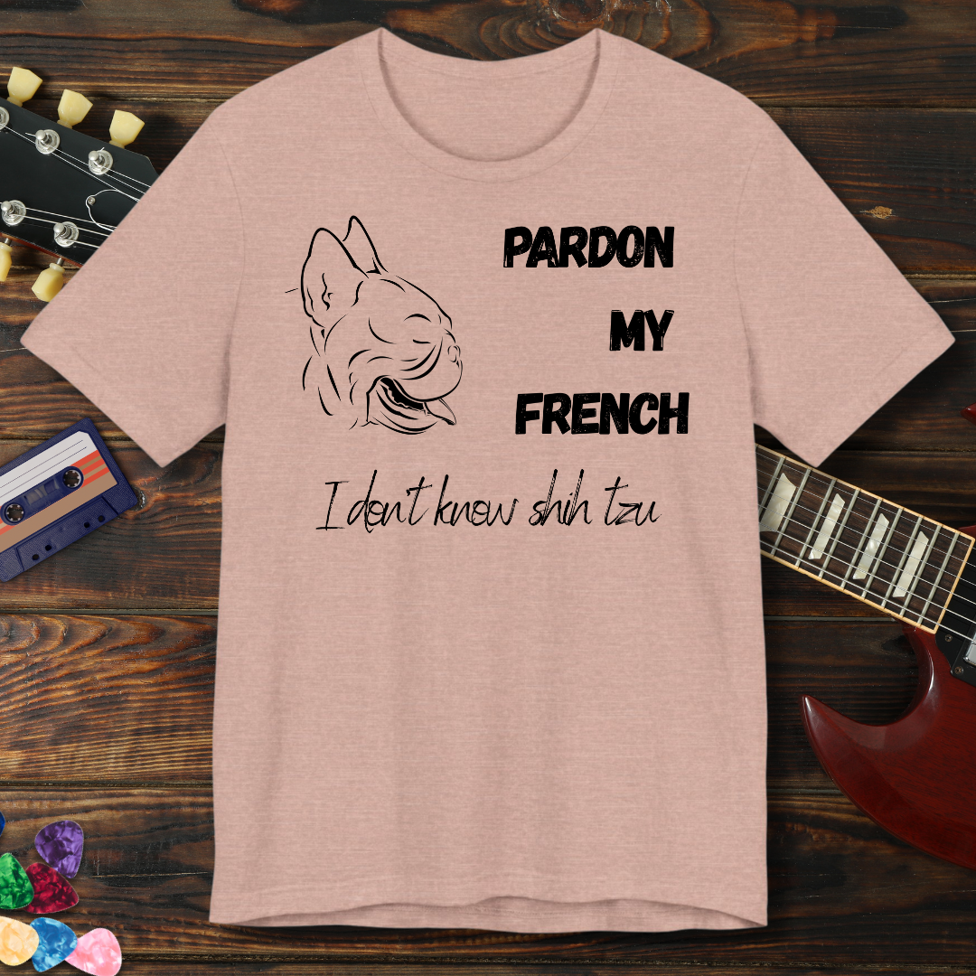 Beige t-shirt with dog illustration and text on a wooden surface with a guitar and cassette tape.