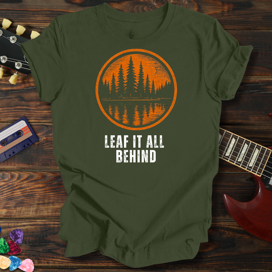 Green t-shirt with orange and white graphic design on a wooden surface with a guitar and cassette tape.