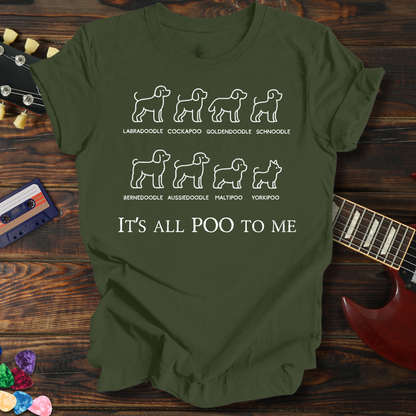 Green t-shirt with dog breed illustrations and text on a wooden surface with a guitar and cassette tape.