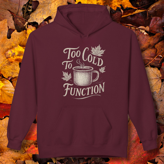 Maroon hoodie with 'Too Cold To Function' graphic on a background of autumn leaves