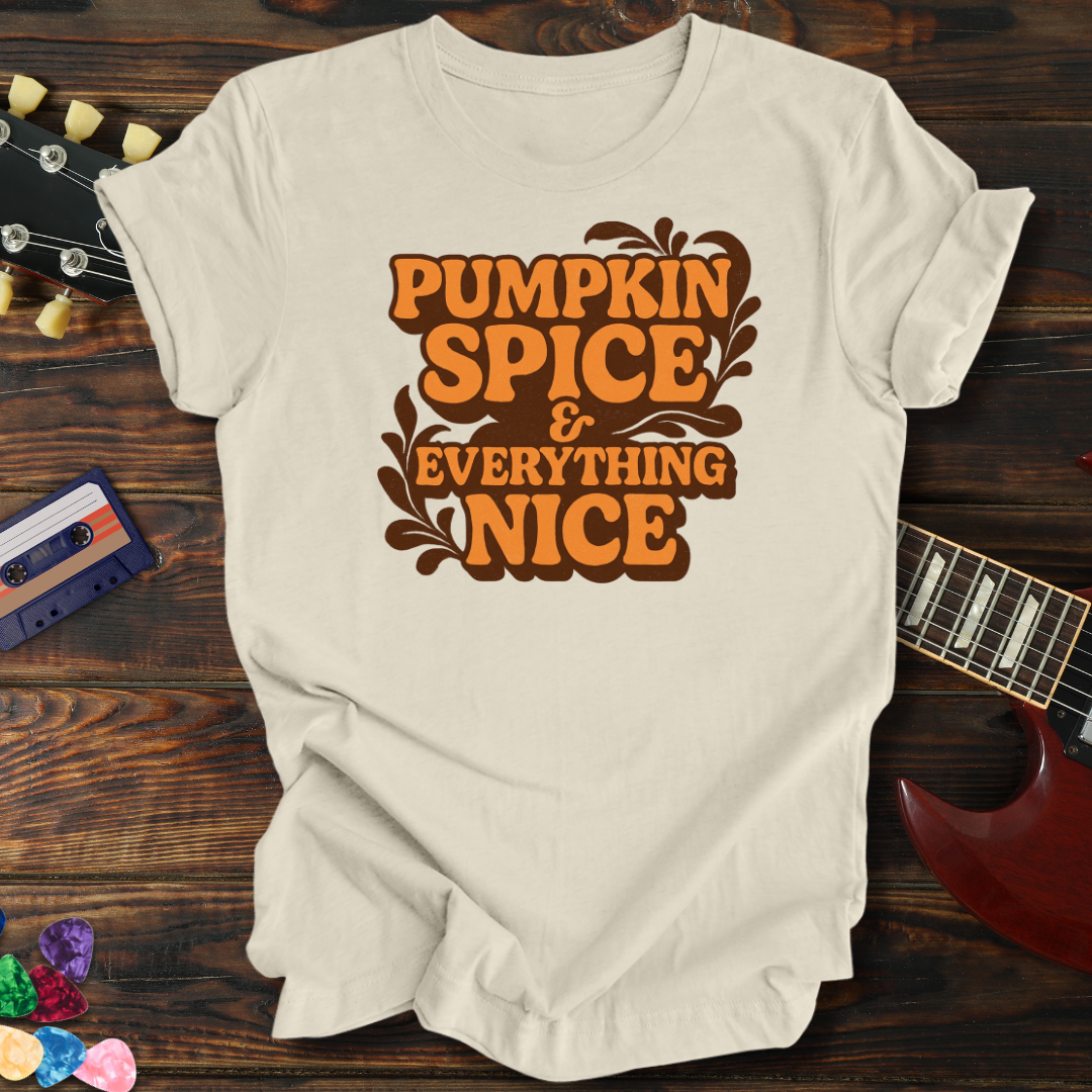 Beige t-shirt with 'Pumpkin Spice & Everything Nice' text on a wooden surface with a guitar and cassette tape.