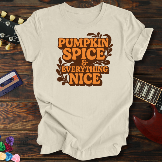 Beige t-shirt with 'Pumpkin Spice & Everything Nice' text on a wooden surface with a guitar and cassette tape.
